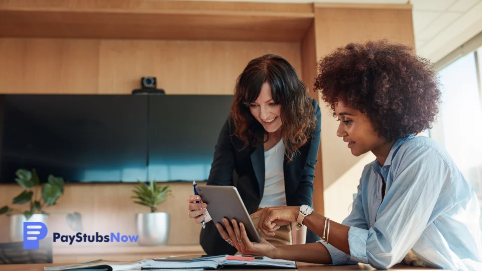 Two people working on a tablet computer in an office