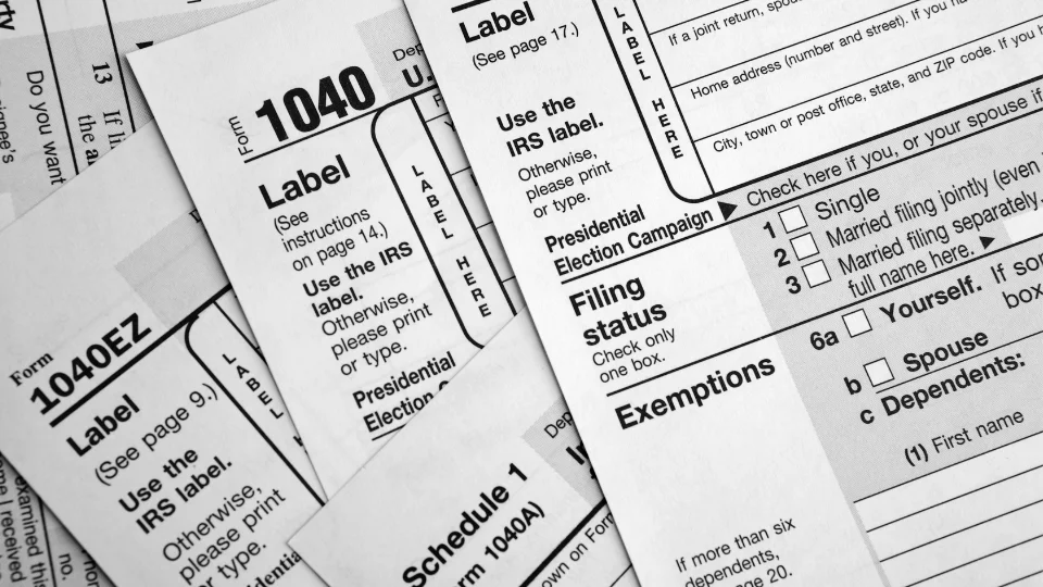 A stack of tax forms neatly arranged on a desk, ready for review or filing