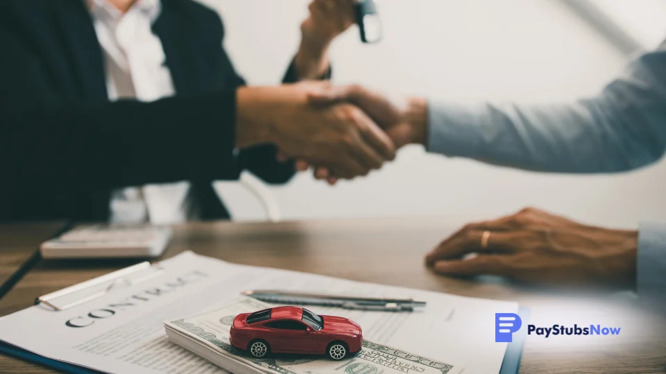 Two people shaking hands over a car on a desk