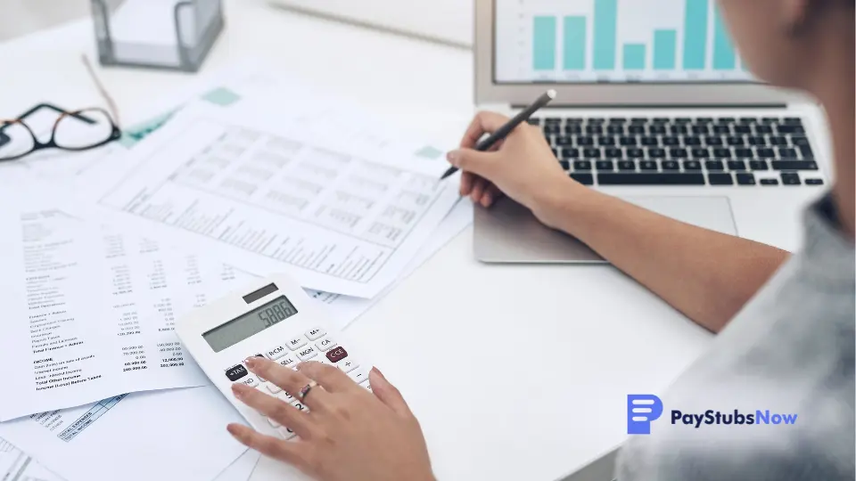 business person working on financial documents at desk with laptop and calculator